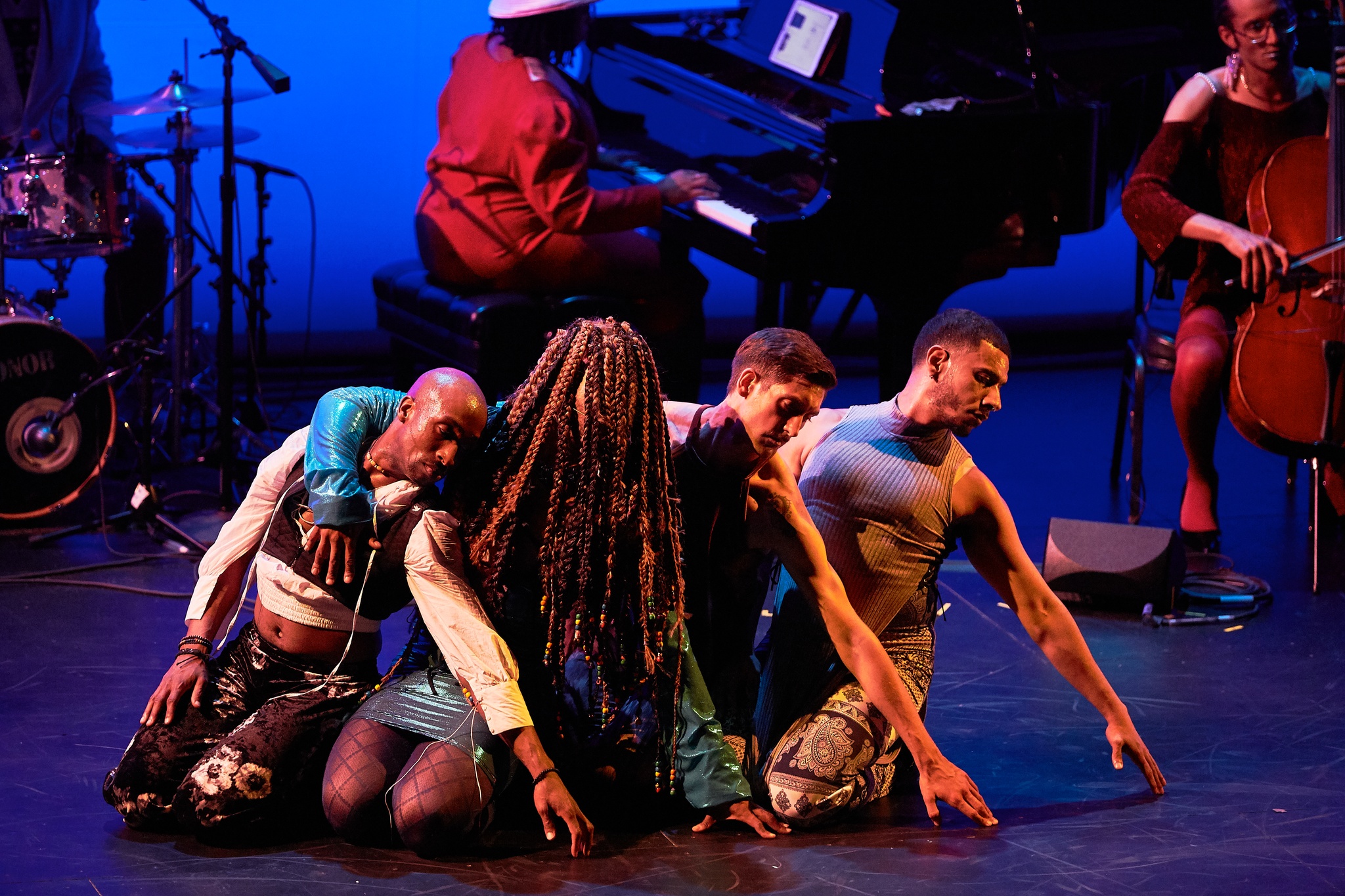 Four dancers performing on a stage.