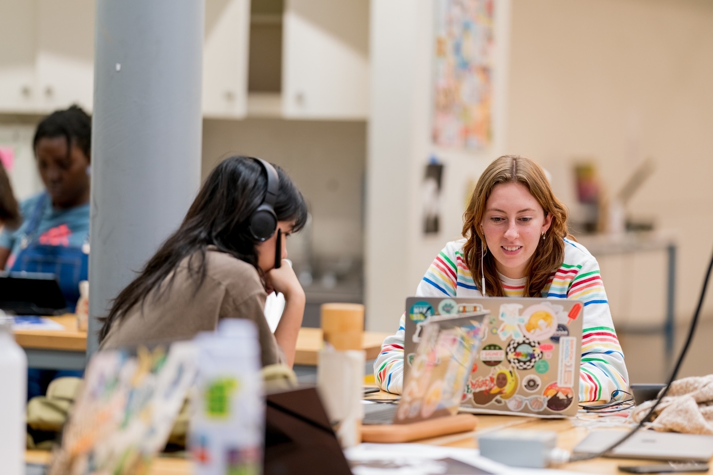 Two students sitting across from each other working on computers