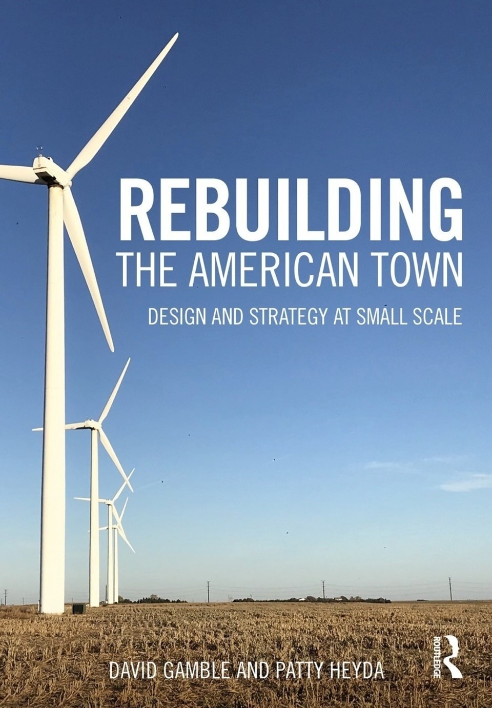 book cover for Rebuilding The American Town by Patty Heyda. Image of windmills on the left of an open field and a vast blue sky