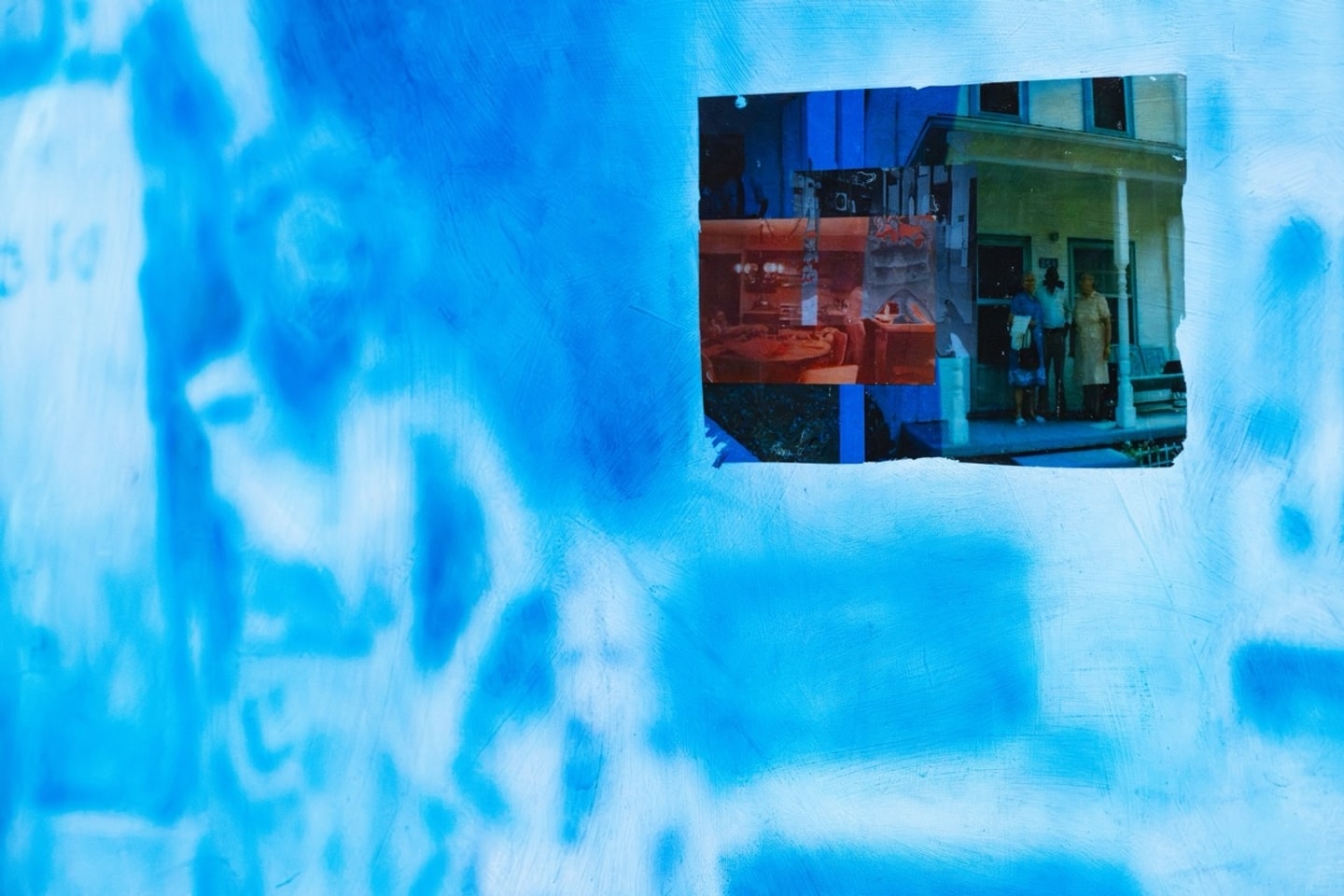 a pink panel and a blue panel with ink over black and white prints of people 