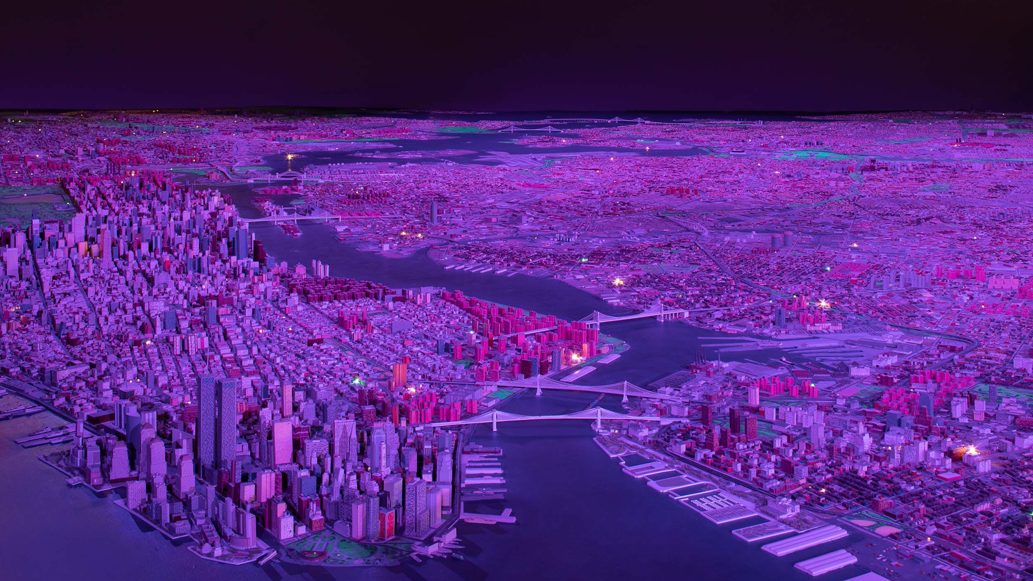 A scale model of New York City bathed in deep purple light as if in the middle of the night