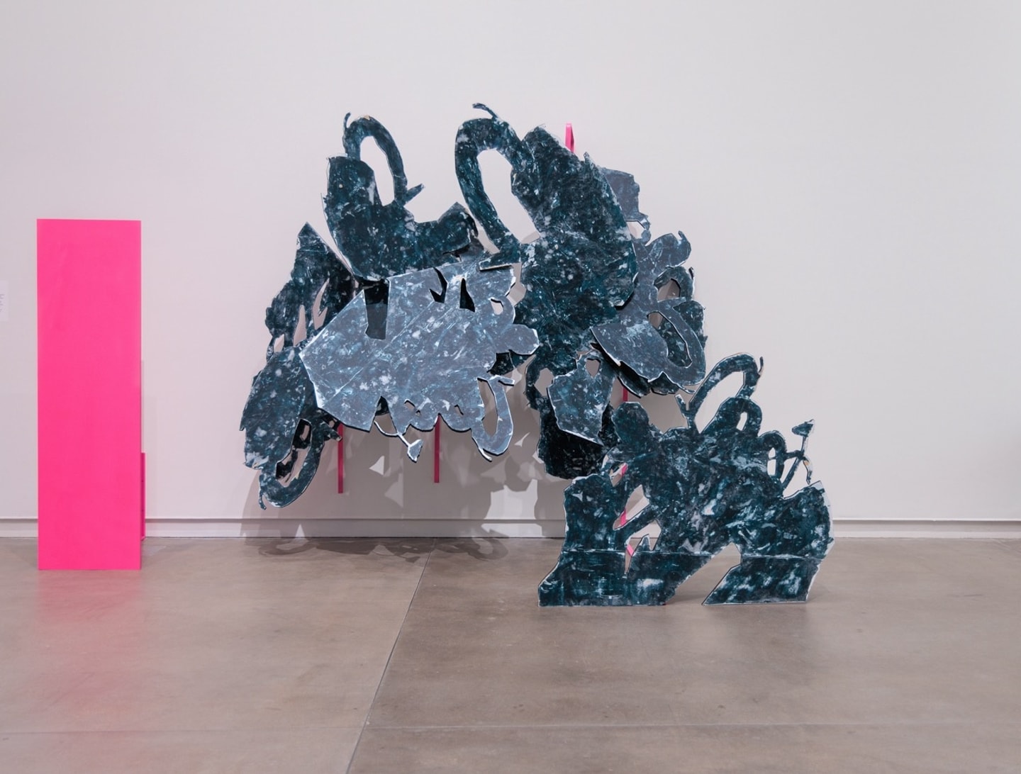 large abstract sculpture in grays and neon pink
